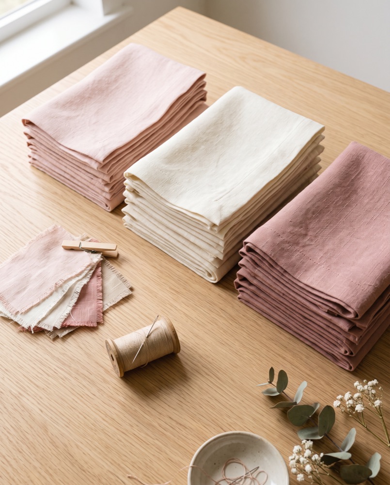 Folded pastel cushion covers on a light wooden table